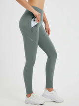 Woman wearing grey waterproof fleece cycling leggings with side zip pocket and reflective accents.