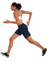 Navy blue women's 7-inch running shorts with built-in liner, worn by athletic woman running. #color_Navy Blue