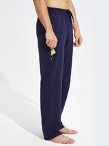 Men's navy cotton yoga cargo pants with zippered side pocket holding a yellow card. #color_Navy Blue