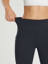 Close-up of dark fleece-lined cycling leggings demonstrating high waistband stretch and side pocket #color_Black
