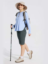 Woman hiking in dark gray 11" cargo shorts, light blue top, sun hat, backpack, and trekking pole. #color_Dark Gray