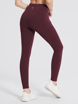 Woman in burgundy fleece-lined hiking leggings with V-waistband and side pocket. #color_Wine Red