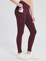 Burgundy fleece-lined hiking leggings with V-waist and side pocket holding smartphone. #color_Wine Red