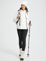 Smiling model in black thermal knit leggings with trekking poles and winter gear. #color_Black