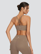 Taupe criss-cross strap low impact sports bra with high-rise Bermuda shorts, back view. #color_Brown