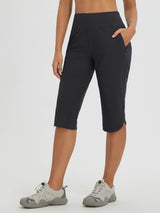 Women's black capri pants for cycling and hiking, featuring pockets and curved hem. #color_Black