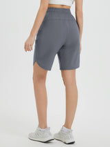 Women's grey 9-inch cycling shorts, back view, showing relaxed fit and side slit. #color_Dark Gray