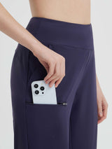 Navy 14" casual cycling capris for women, hand placing phone in thigh zippered pocket. #color_Navy Blue