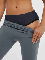 Women's padded cycling underwear in dark grey, shown under grey cycling shorts. #color_Black
