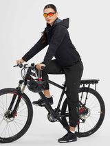 Woman in black elastic tapered cycling pants on bike with reflective details. #color_Black