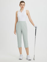 Woman wearing light green high-waisted cropped golf pants, 20-inch inseam, holding club. #color_Light Gray