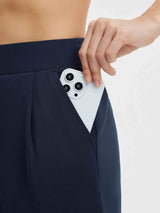 Navy blue Golf pleated fleece slim-fit pants, showing phone in pocket. #color_Navy Blue