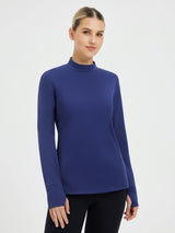 Woman wearing blue skiing fleece pullover base layer with mock neck and thumbholes. #color_Navy Blue