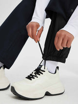 Women's black ski softshell flared pants with adjustable ankle detail. #color_Black