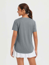 Heather gray women's outdoor short sleeve crew neck t-shirt with high-low hem, paired with a white skort.