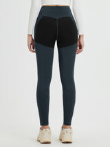 Back view of dark teal slim-fit knit fleece outdoor pants with black rear thigh panels & pockets.