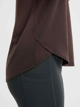 Brown long-sleeve running t-shirt with crossover hem detail and dark athletic leggings. #color_Dark Brown