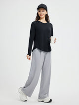 Black long-sleeve running t-shirt with crossover hem & thumbholes. Breathable athletic wear. #color_Black