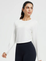 Women's crew-neck long-sleeve running shirt in white with ruched sides and thumb holes.