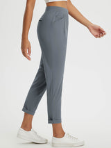 Grey high-rise tapered trousers with rolled cuffs, suitable for everyday travel and wear.