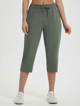 Woman wearing olive green Baleaf 19" quick-dry yoga capri pants with pockets and drawstring. #color_Army Green