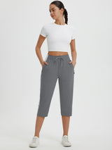 Gray women's 19" quick-dry yoga capri pants with white side stripes and drawstring waist. #color_Dark Gray