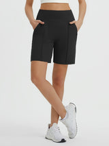 Black Women's 7" Bermuda shorts with loose fit, four pockets, worn with white sneakers.