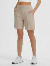 Women's 7" Bermuda long shorts in khaki with elastic waistband and pockets, paired with white sneakers. #color_Khaki