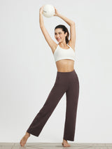 Eggplant high-waisted wide-leg yoga commuter pants shown on model holding BLOOM ball. #Color_Dark Brown