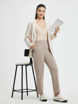 Model wearing taupe yoga tapered pants, beige blazer, holding tablet. #color_Teak Brown