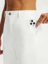 Baleaf white straight leg golf pants: hand inserting phone into front pocket. #color_White