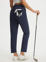 Woman in navy Baleaf stretchy wrinkle-free golf pants, 25'' length, holding golf club. #color_Navy