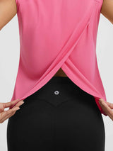 Pink Baleaf crop tank top with crisscross open back detail, paired with black leggings. #color_Hot Pink