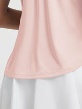Pink UPF50+ workout tank top with curved hem, worn with a white skirt. #color_Pink Dogwood