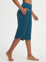 Teal Baleaf 17" high-rise capri pants with functional side pockets and curved split-hem. #color_Deep Blue