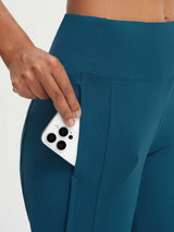 Teal Baleaf high-rise 17" capri pants featuring a large side pocket holding a smartphone. #color_Deep Blue