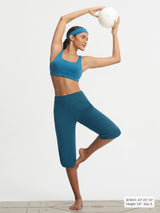 Baleaf women's teal high-rise stretchy 17" capri pants in yoga pose. #color_Deep Blue