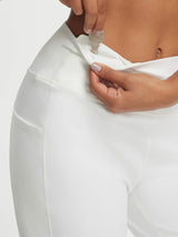 White Baleaf high-rise wide leg pants: hand inserts key into zippered waistband pocket. #color_White