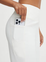 Woman placing smartphone in deep pocket of Baleaf white ultra-soft high-rise wide leg pants. #color_White