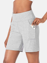 Light gray athletic shorts with a high waist and pockets, a phone is being placed into one pocket. #color_Light Gray