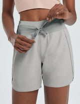 Women's light grey high-waisted running shorts, 5" inseam, with drawstring detail and side pockets.