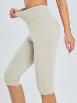 Laureate women's pocketed yoga capris: high-waisted, light beige, showing stretch.