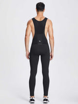 Men's black fleece bib cycling tights back view with reflective logo and side pockets. #color_Black