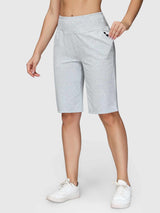 Light gray women's 12" cotton Bermuda shorts, high waist, side pockets, worn with white sneakers. Loose fit.