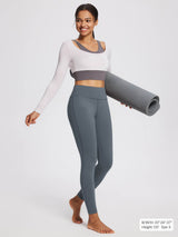 Women's petite grey fleece-lined yoga leggings with high waistband, model holding mat.