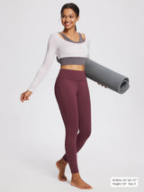 Women's petite burgundy fleece-lined yoga leggings with high waistband, model holding yoga mat.