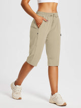 Woman wearing beige DWR pocketed capri pants for everyday outdoor comfort and hiking. #color_Doeskin