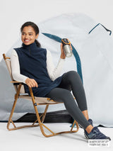Woman in navy blue fleece thermal sleeveless dress by tent.