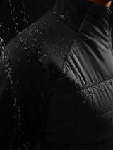 Black quilted women's outdoor jacket fabric with water droplets, showing water resistance. #color_Black