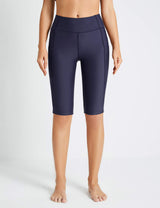 Navy blue Flyleaf UPF50+ high-rise swim shorts with pockets on a woman.